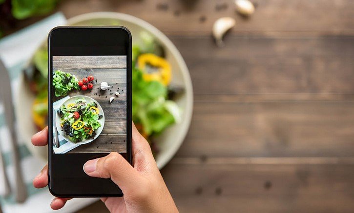 a person taking a picture of food 